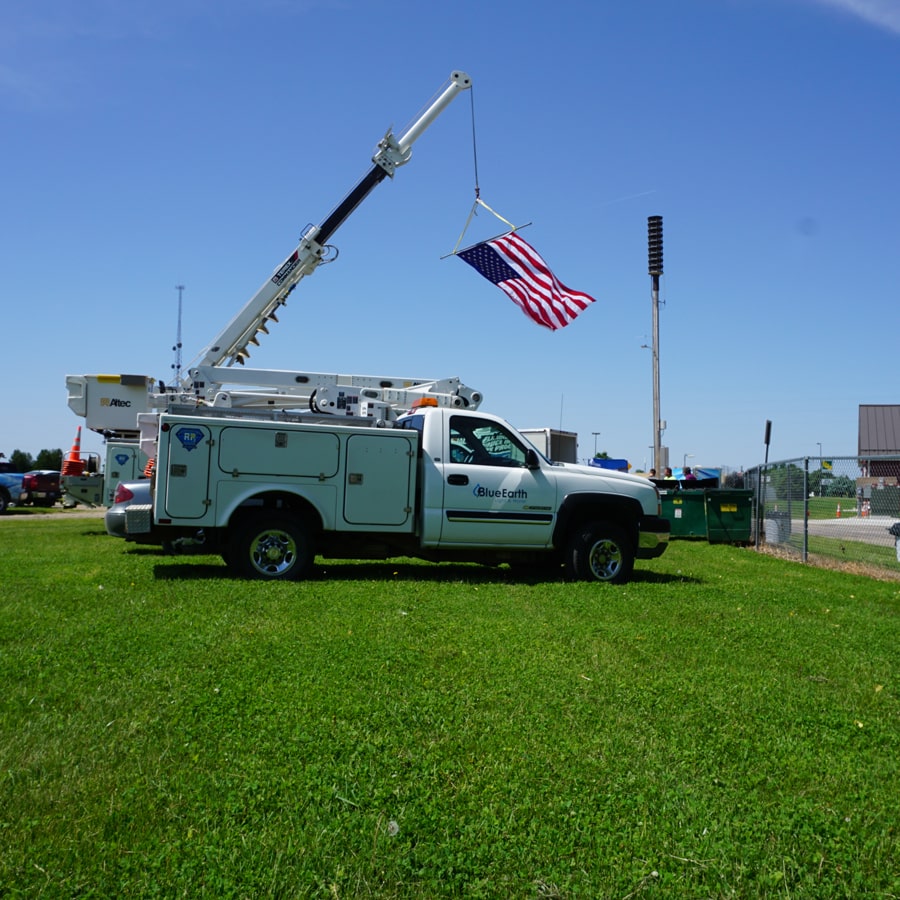 Blue Earth Utility Truck with American Flag Hanging from it